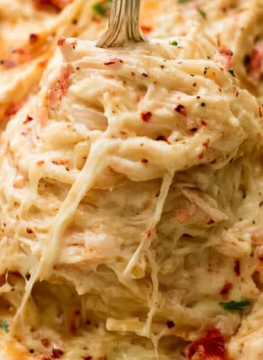 Cheesy Chicken Spaghetti Casserole served in a baking dish with garnishes.
