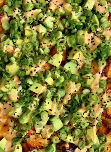 Healthy salmon sushi bake topped with fresh ingredients and herbs